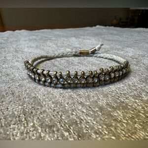 Braided bracelet with rhinestones and gold accents.